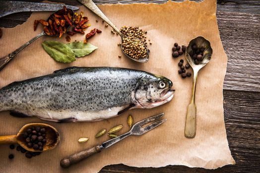 fresh trout with seasonings in a spoons on a table