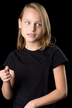 Beautiful girl posing in the studio. Close up portrait of beautiful blonde teenage girl in black t-shirt gesturing against black background.