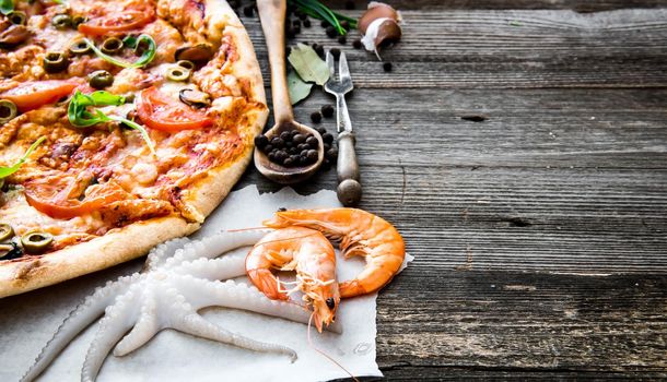 delicious pizza with seafood on wooden table