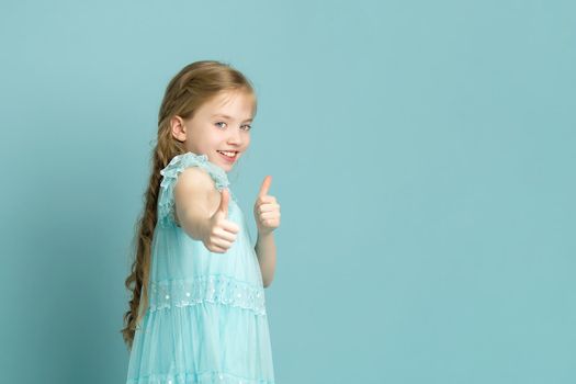 Little girl holding her thumb up. Concept Happy childhood, holiday, birthday.