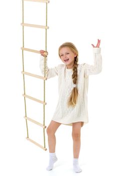 The girl climbs the rope ladder. Cheerful child on a white background. Active healthy lifestyle concept