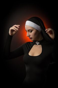 The Fine art portrait of a novice nun in deep prayer with rosary