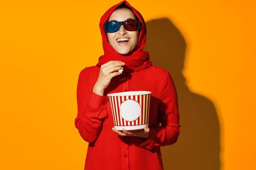 arab woman popcorn entertainment cinema yellow background. High quality photo