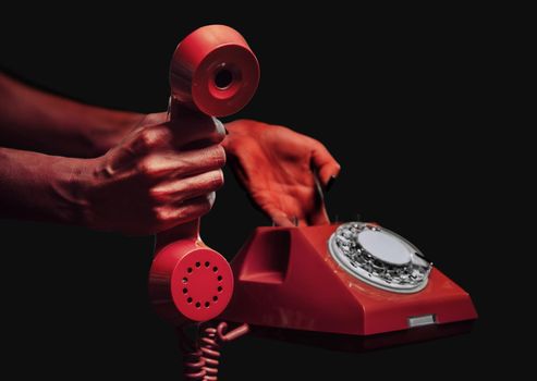 Devil hands giving vintage red phone on dark background, space for text, Halloween or horror theme