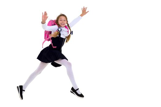 Smiling schoolgirl happily jumping high. Joyful primary school girl in uniform having fun isolated on white background. Back to school, education concept