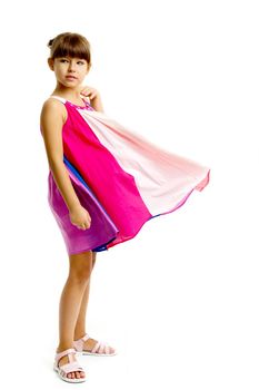 Adorable girl posing in fluttering dress. Beautiful girl posing in studio on isolated white background. Full length portrait of cute preteen child in summer dress half sided to the camera