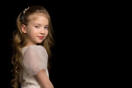 Beautiful little girl on a black background. Studio photography.Close-up.
