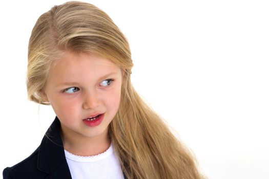 Portrait of adorable blonde little girl. Curious beautiful long haired schoolgirl standing against white background. Lovely elementary school student in blue jacket and white blouse