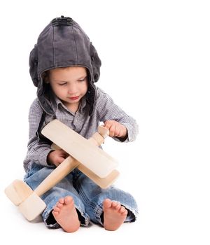 little boy with pilot hat playing toy plane isolated on white background