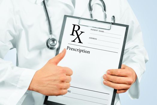 Unrecognizable man doctor shows gesture thumb up in front of clipboard with prescription paper