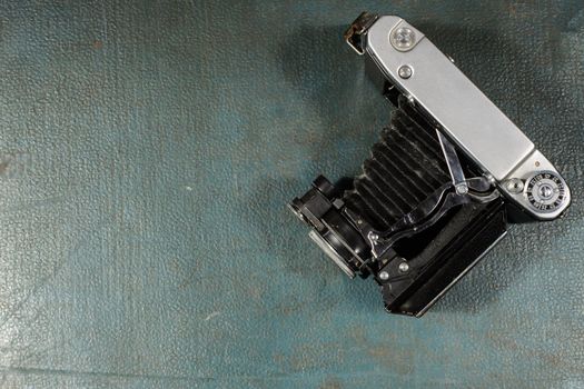 Old vintage camera on a blue scratched background. Top view