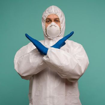 A male doctor in protective overalls and a mask shows stop sign. Coronovirus protection concept in China. - image