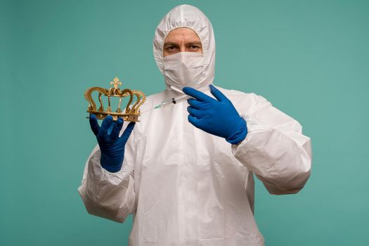 A male doctor in protective overalls and a mask makes an injection in the crown. Coronovirus protection concept in China. - image