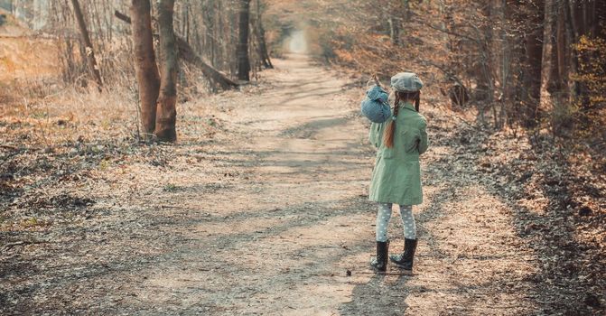 little girl goes through the woods with stuff, photo in vintage stylev