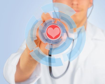 Man doctor listens with stethoscope, red heart is painted on stethoscope, concept of health