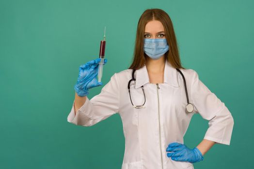 Covid19, coronavirus. Portrait of professional confident young caucasian doctor in medical mask and white coat, stethoscope over neck,with vaccine syringe in hand, fight disease - image