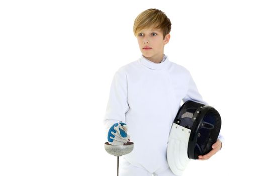 Boy in fencing costume posing with sabre and mask. Portrait of handsome teenage boy fencing player wearing white uniform standing with foil against white background.