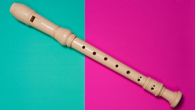 White plastic flute isolated on colored background