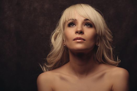 Close-up portrait of a beautiful blonde girl looking up. woman with clean and lifted skin