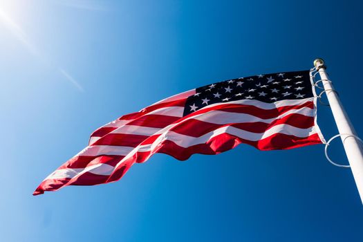 american flag waving in blue sky