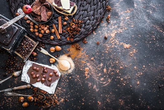 chocolate, cocoa and various sweet spices on black table