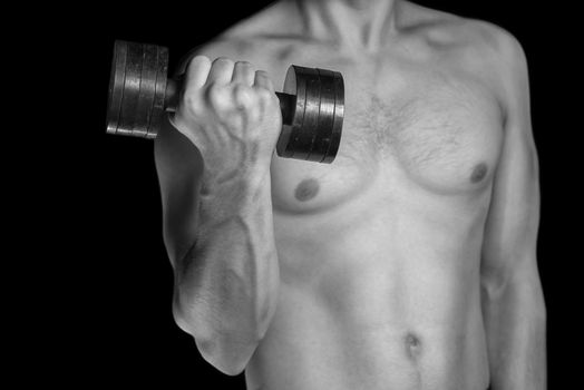 Man is exercising with a dumbbell, monochrome image