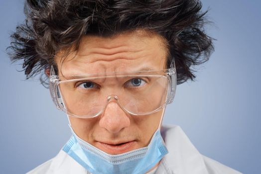 Portrait of crazy surprised man scientist in glasses and mask