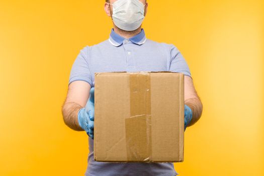 Man holding cardboard boxes in medical rubber gloves and mask. Coronavirus pandemic quarantine delivery concept