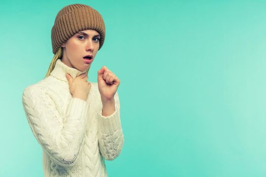 The girl has symptoms of coronavirus. Cold And Flu. Portrait Of Beautiful Young Female With Cough And Sore Throat Feeling Sick Indoors. Closeup Of Ill Unhealthy Woman Coughing