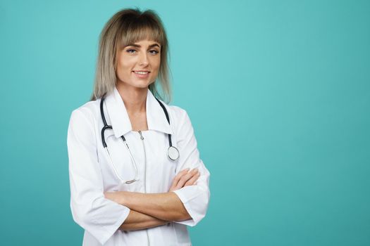 Cheerful happy doctor with crossed hands on blue background