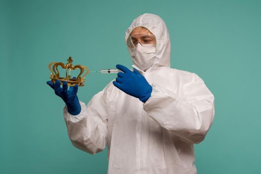 A male doctor in protective overalls and a mask makes an injection in the crown. Coronovirus protection concept in China. - image