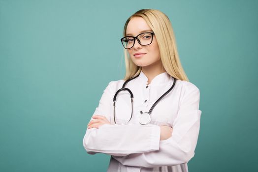 Smiling young medical doctor woman with stethoscope. Isolated over blue background.