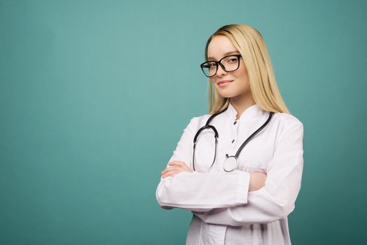 Smiling young medical doctor woman with stethoscope. Isolated over blue background.