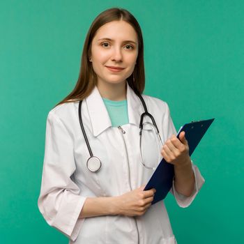 Happy smiling young female doctor with clipboard, isolated over background - image