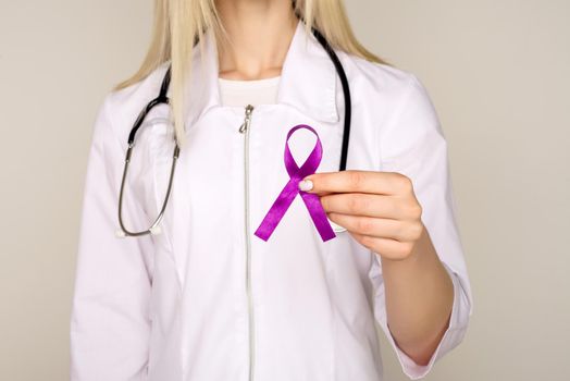 Female doctor in white uniform with purple awareness of ribbon in hand for ADD,ADHD,Alzheimer Disease ,Arnold Chiari Malformation,Childhood Hemiplegia stroke, Epilepsy, Chronic Acute Pain,Crohns - Image