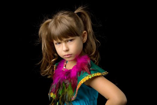 Portrait of girl with angry face expression. Beautiful preteen girl dressed colorful ethnic costume standing against black background. Child with serious face expression posing in studio