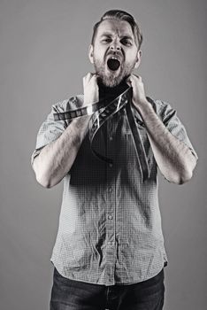 an angry man screams with a film on his neck.