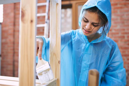 woman in protective suit painting wood renovation design. High quality photo