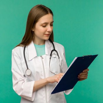 Happy smiling young female doctor with clipboard, isolated over background - image