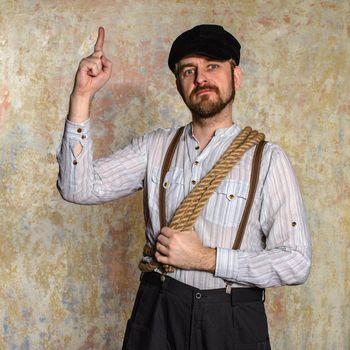 Excited man pointing a great idea adjusting his suspenders with rope