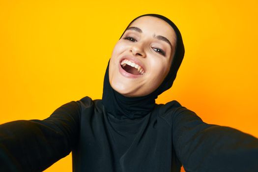 cheerful woman in black hijab posing fashion hand gesture isolated background. High quality photo