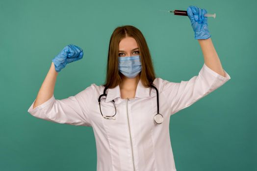 Covid19, coronavirus. Portrait of professional confident young caucasian doctor in medical mask and white coat, stethoscope over neck,with vaccine syringe in hand, fight disease - image
