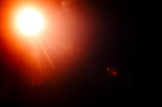 Abstract Natural Sun flare or Far star on the black background - image
