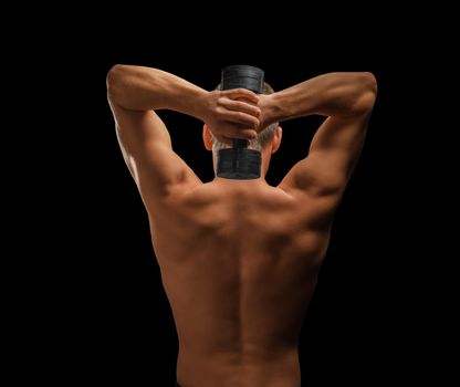 Muscular man exercises with dumbbell, rear view