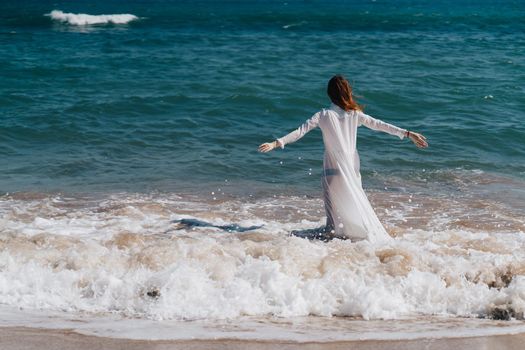 Woman in white dress near the ocean walk fresh air landscape. High quality photo