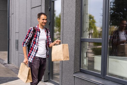 delivery, mail and people concept - happy man delivering food in disposable paper bag to customer home