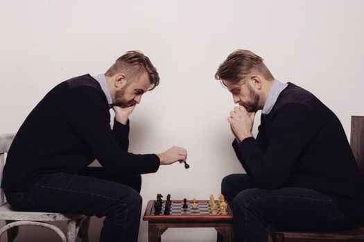 man playing chess against himself. makes a move