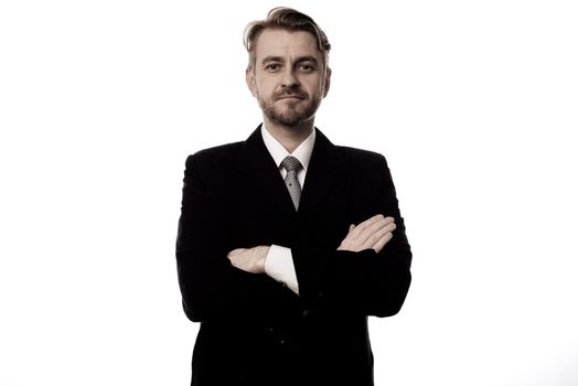 Smiling businessman standing with arms folded isolated on white background.