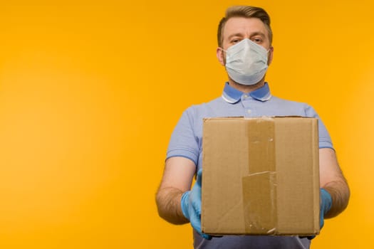 Man holding cardboard boxes in medical rubber gloves and mask. Coronavirus pandemic quarantine delivery concept