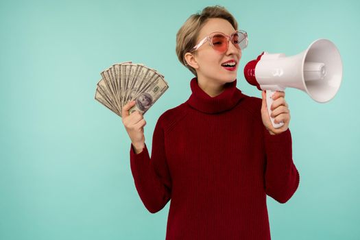 Young woman in pink sunglasses with money yelling to loudspeaker - image